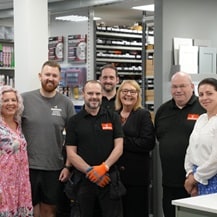 A group of Howdens workers pose together while smiling