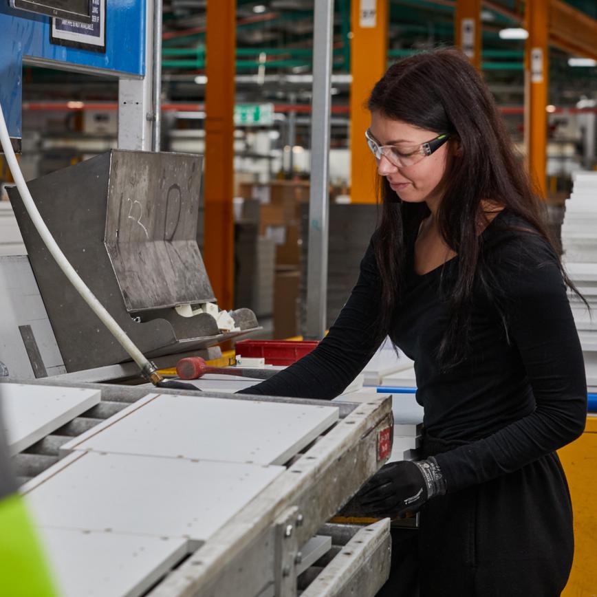 Image of a young woman, working on the manufacturing line