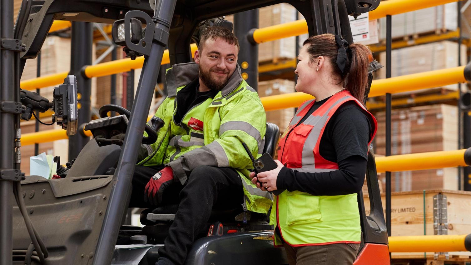 Job Seeker Tips - Hero Image Man and woman looking at eachother, the man sat higher in a forklift