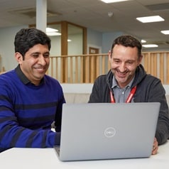Part of the Howdens insights team, in the commercial and supply chain department, meeting in an office around a laptop.