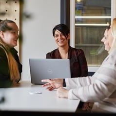 Four members of the supply chain planning team, part of the commercial and supply chain department, in an office room.